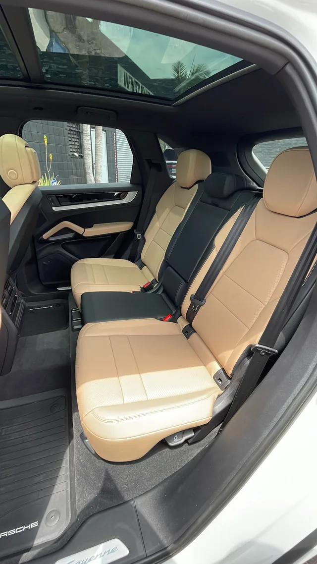 Tan rear bench seats and panoramic glass roof in the Porsche Cayenne