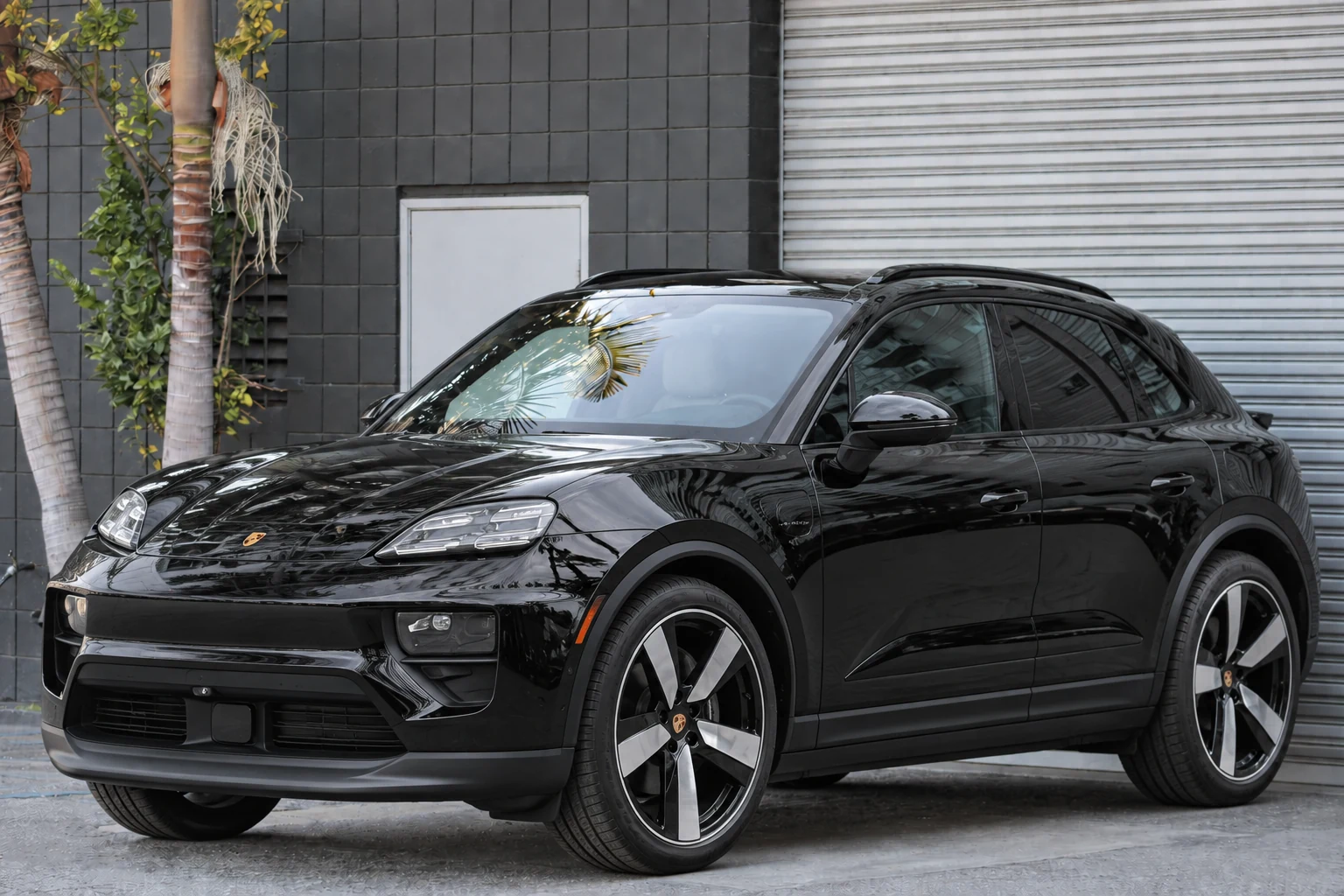 Black Porsche Macan 4 Electric at BLU Motors — front three-quarter view
