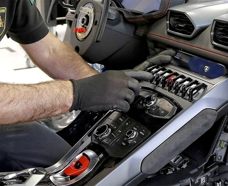 A certified technician servicing a luxury vehicle in a clean professional workshop