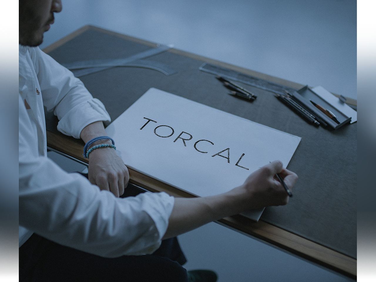 A designer hand-lettering a concept sketch